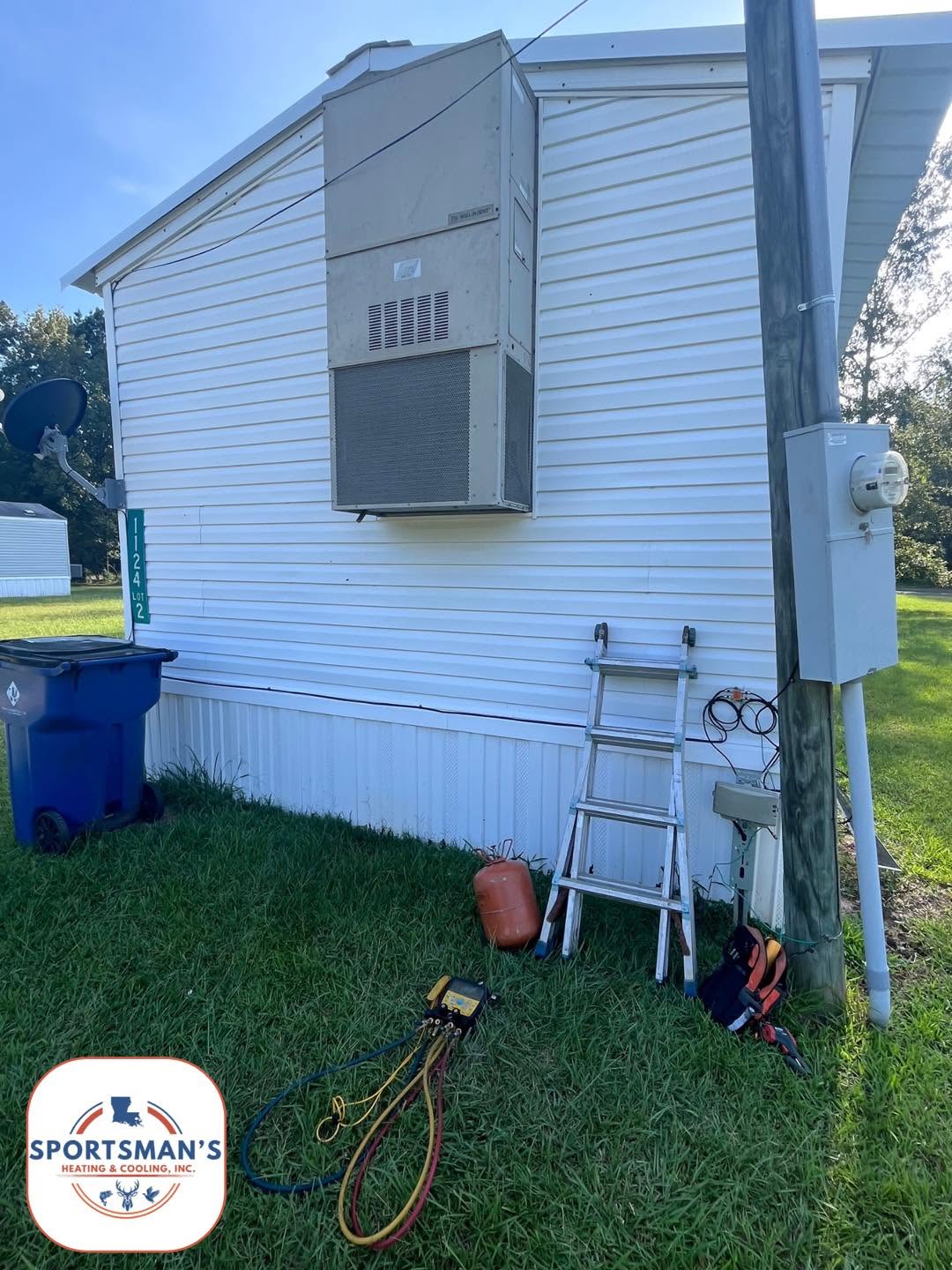 Wall-mounted HVAC unit on a home exterior during a service visit